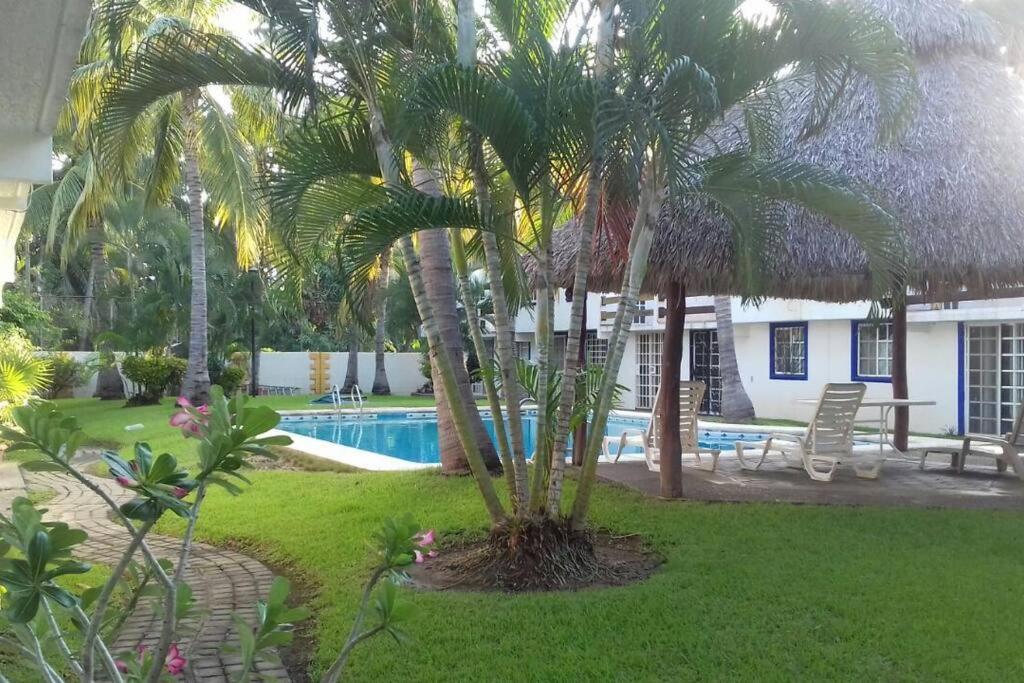 a resort with a swimming pool and palm trees at Casa en la zona de Acapulco diamante in La Sabana