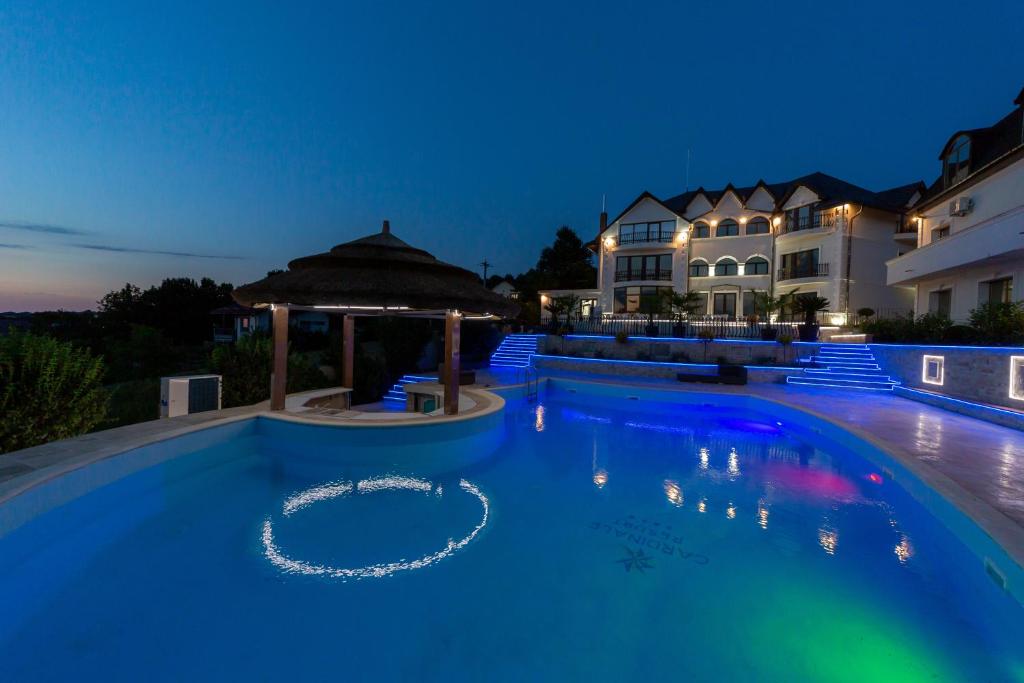 a large swimming pool in front of a house at Cardinale Resort in Iaşi