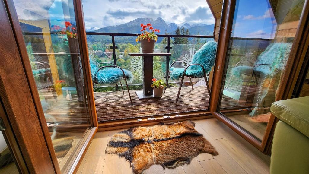 Polana Szymoszkowa Ski Resort - Chamerion Apartments في زاكوباني: غرفة مطلة على شرفة مع كراسي