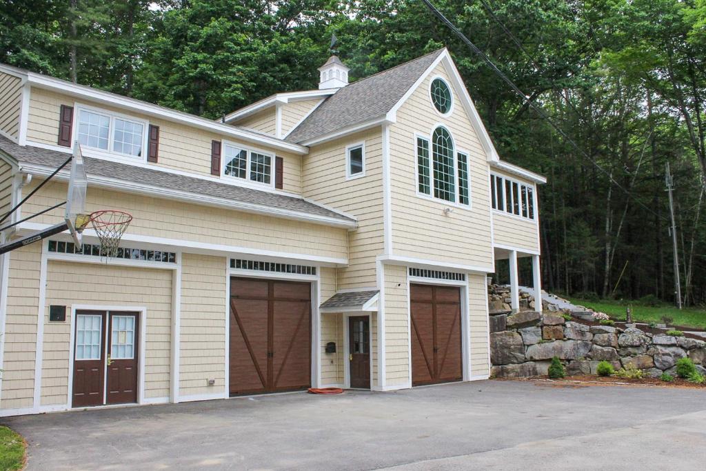 a house with two garage doors and a basketball hoop at Stoneybrook Retreat Haven in State Landing