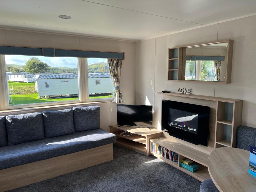 ein Wohnzimmer mit einem Sofa und einem TV in der Unterkunft Haven Craig Tara Holiday Park - GD's Caravan Hire in Ayr