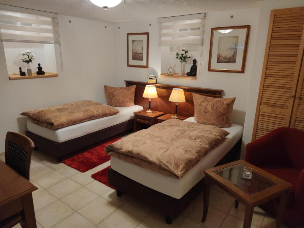 Zimmer mit 2 Betten, einem Sofa und einem Tisch in der Unterkunft Ferienzimmer Familie Schmidt in Großdeuben