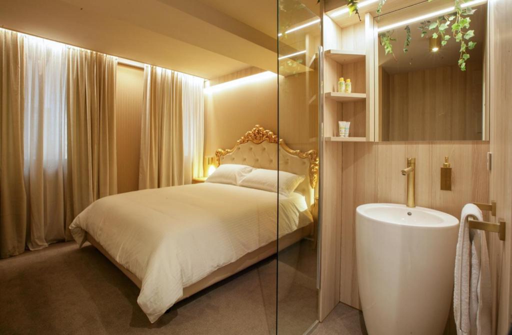sypialnia z łóżkiem oraz łazienka z umywalką w obiekcie The Venice Nest @ Ca' Del Duca w Wenecji