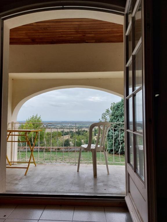 una silla sentada en un balcón con vistas en La Ginelle - Appartement Terrasse en Airoux