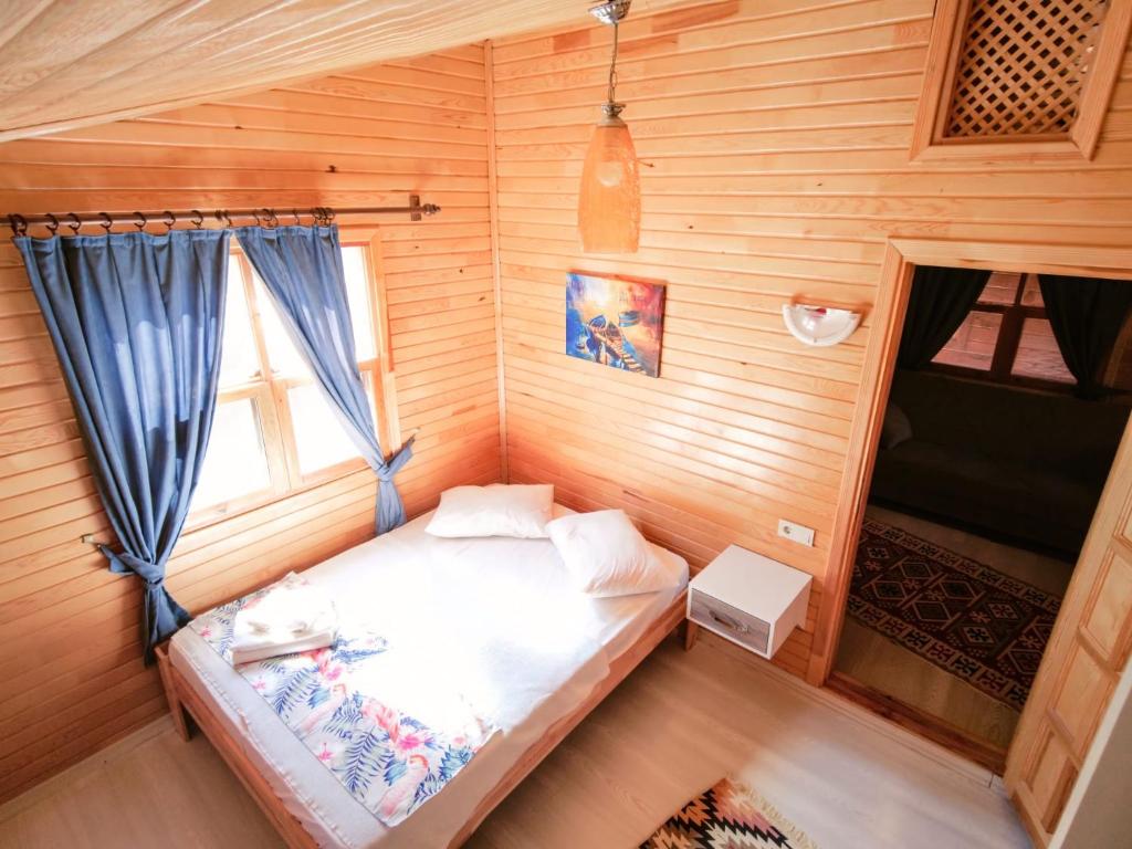 a small bedroom with a bed in a wooden cabin at Adrasan LilAmor ile evinizin konforunda bir tatil in Kumluca