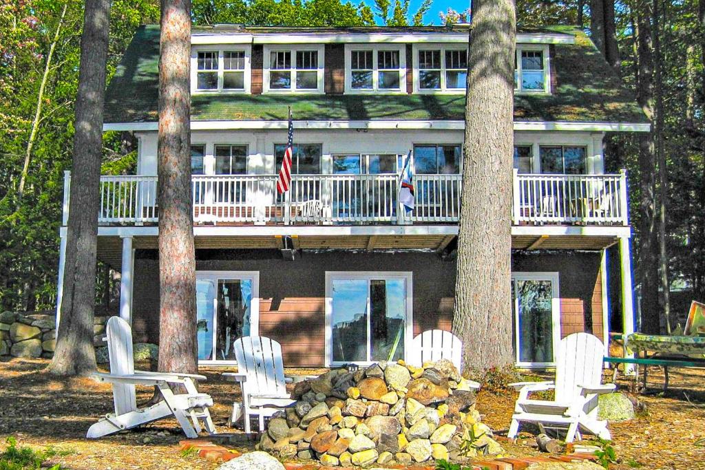 a house with a bunch of chairs in front of it at American Dream on Lake Winnipesaukee in Meredith