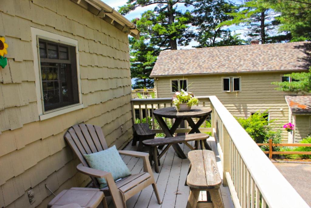 a patio with two chairs and a table on a balcony at Varney Point Studio in Gilford