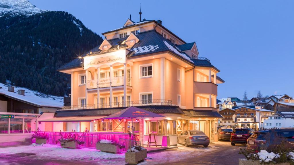 a large building with a pink fence in front of it at Hotel24Steps in Ischgl