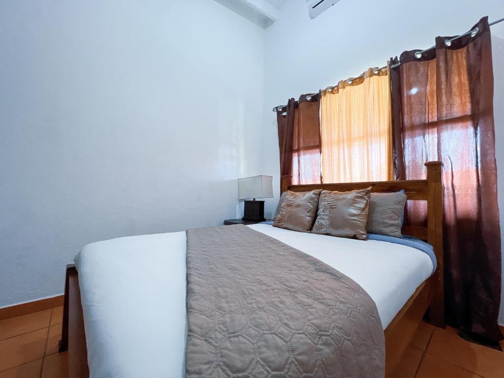 - une chambre avec un lit blanc et une tête de lit en bois dans l'établissement Villa Paraíso Mango 4, Steps from the Beach & Free WIFI, à Jacó