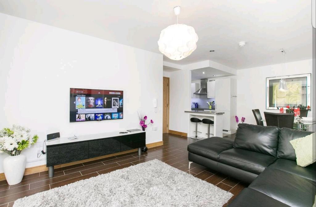 uma sala de estar com um sofá e uma mesa em Victoria Place apartment em Belfast
