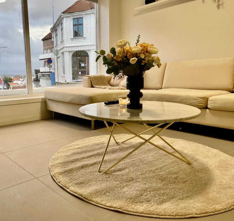 un salon avec une table avec un vase de fleurs dessus dans l'établissement The Black Door., à Stavanger