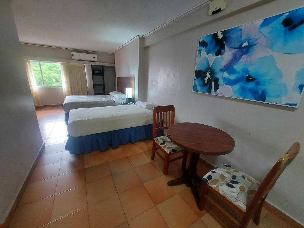 sypialnia z łóżkiem, stołem i krzesłami w obiekcie Hotel Tower House Suites w Panamie