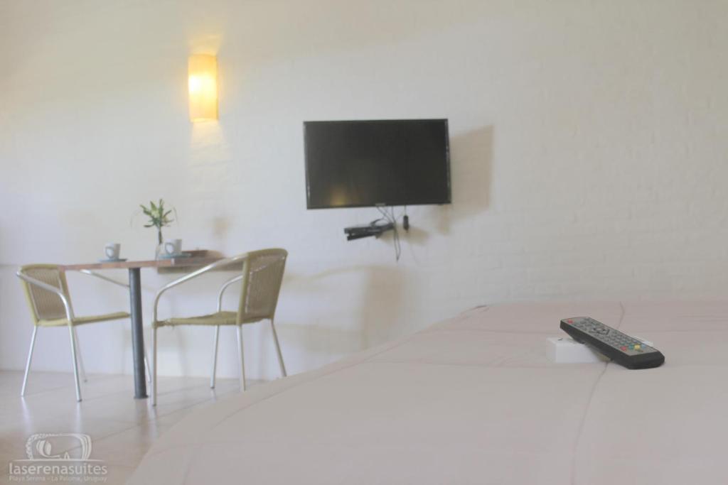 a bedroom with a bed and a table and a tv at La Serena Suites Aparthotel in La Paloma