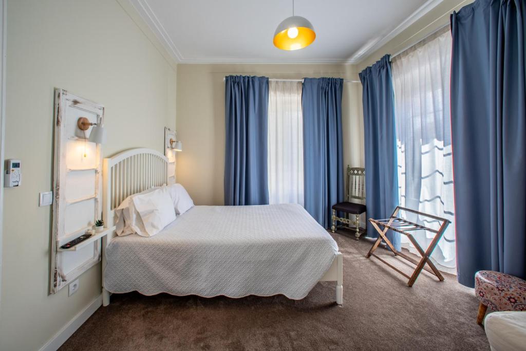 a bedroom with a bed with blue drapes at Graça Garden Torres Vedras in Torres Vedras