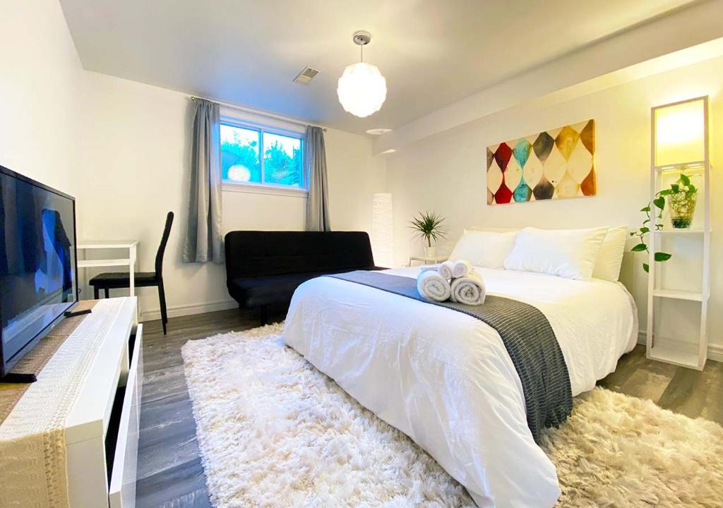 1 dormitorio con 1 cama y TV de pantalla plana en Sunrise Tree BnB - your Home away from home, en Toronto