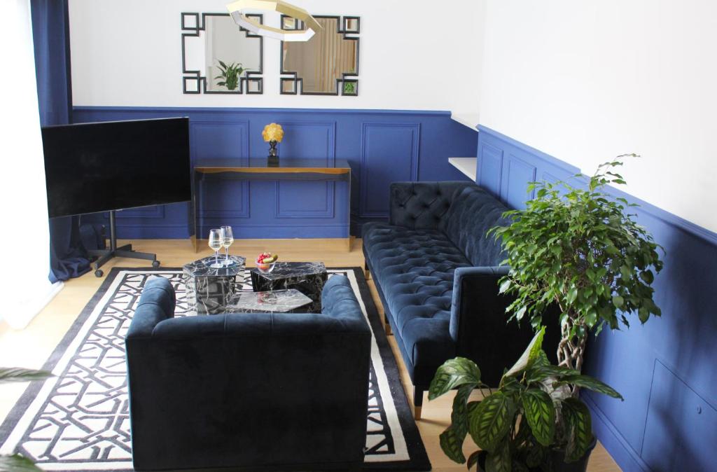 a living room with blue walls and a blue couch at day&night Luxury Apartment, 2 Bedrooms, Terrace, Jacuzzi outdoor, Parking in Trieste