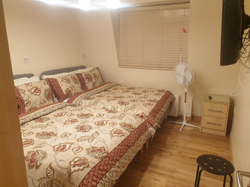 a small bedroom with a bed and a fan at London Luxury 3 bedroom 2 bathrooms flat 1 min to Redbridge Station FREE parking & WIFI in Wanstead