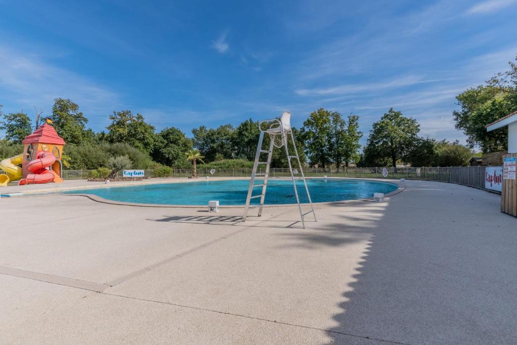 une échelle au milieu d'une piscine dans l'établissement Capfun 5 stars 64 m with pool and terrace, à Lanton