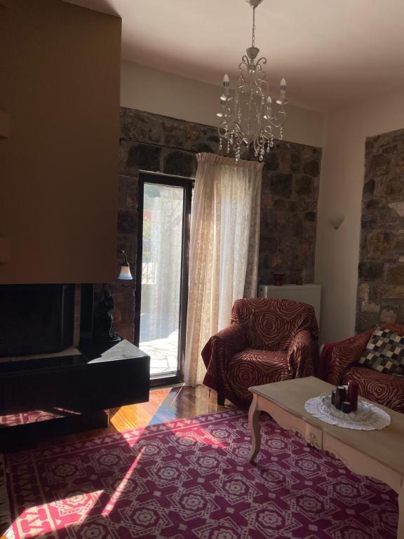 a living room with a couch and a chandelier at Stymfalia Cozy Village Guesthouse in Kartérion