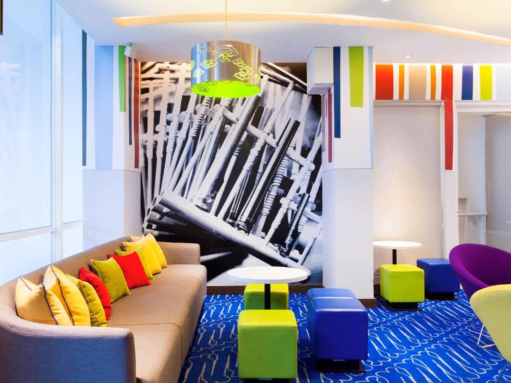 a living room with a couch and colorful chairs at Ibis Budget Bandung Asia Afrika in Bandung