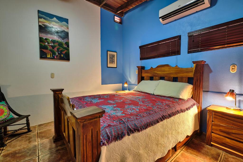 塔瑪琳的住宿－Casa Smilin' Dog，一间卧室设有木床和蓝色的墙壁