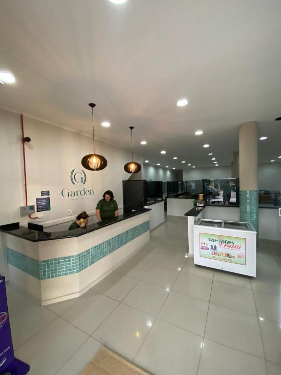 a lobby of a canadian store with people sitting at a counter at Garden Hotel in Aparecida