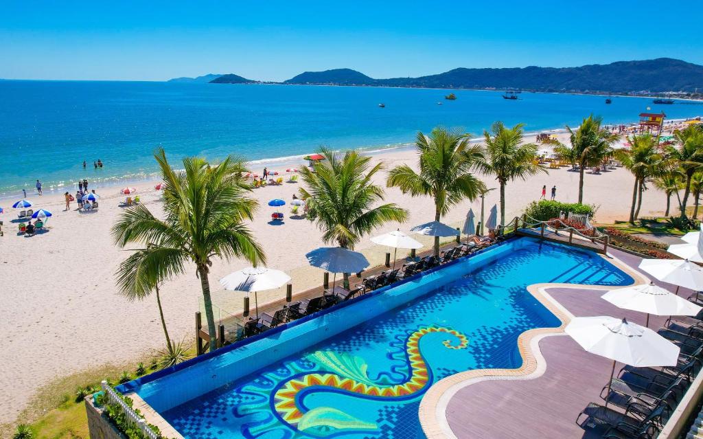 uma vista aérea da praia e da piscina do resort em Palace Praia Hotel em Florianópolis