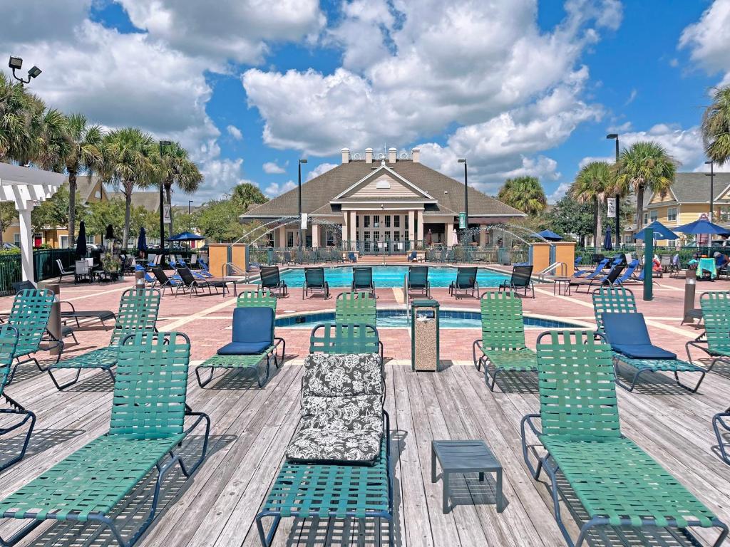 une piscine avec des chaises longues et une piscine dans l'établissement The Villas at Seven Dwarfs - Close to Disney, à Kissimmee