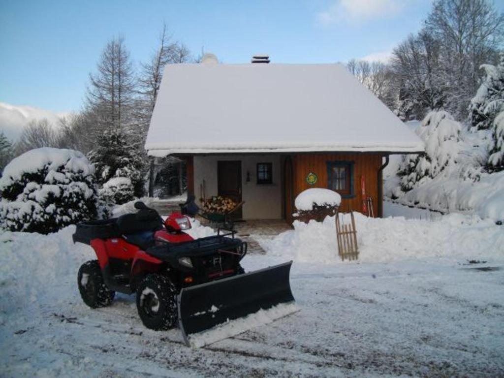 a snowmobile parked in front of a house in the snow at Gîte Anould, 4 pièces, 6 personnes - FR-1-589-2 in Anould