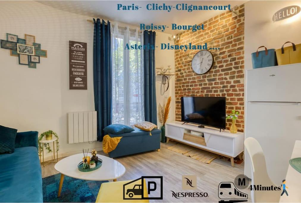 a living room with a tv and a brick wall at Escale à Paris Metro & Parking in Saint-Ouen