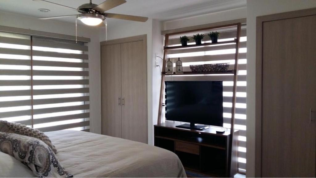 a bedroom with a bed and a flat screen tv at Hermoso Departamento in San Miguel de Allende