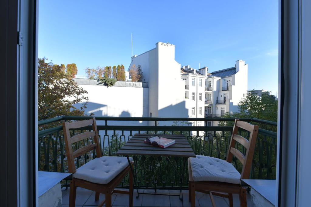 - Balcón con mesa y 2 sillas en Wilcza 3 - Apartament dla 4 osób - 260m do Ambasady USA - Duży balkon od strony dziedzińca - Wifi - Good Apartments, en Varsovia