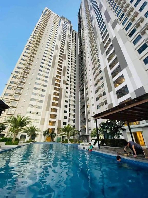 a swimming pool in front of two tall buildings at Jojies Crib Horizons101 Studio in Cebu City