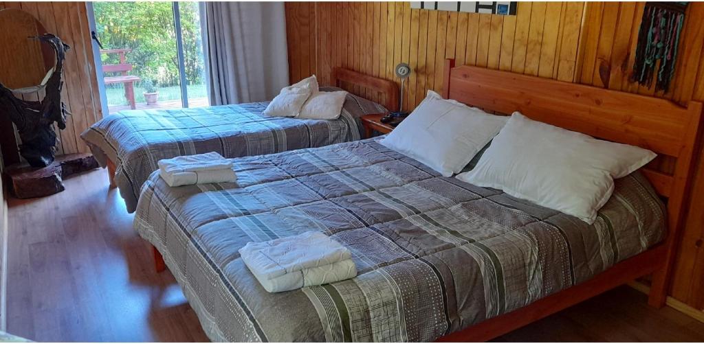 1 dormitorio con 2 camas y ventana en Saida Room Villarrica, arriendo habitaciones, en Pucón
