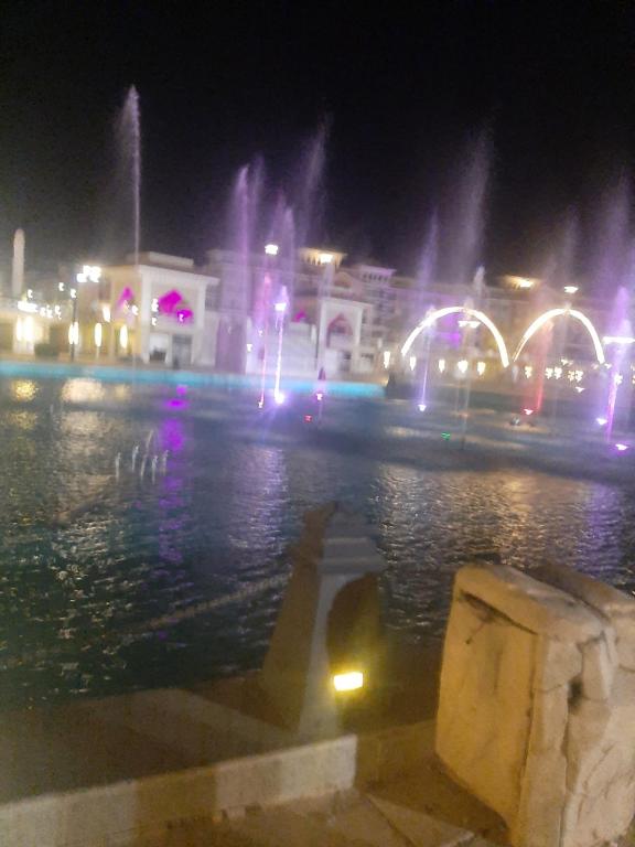 a city at night with a fountain in the water at Chalets in Porto Sharm in Sharm El Sheikh