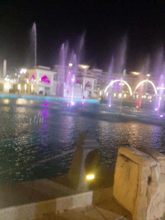 Una ciudad de noche con una fuente en el agua en Chalets in Porto Sharm en Sharm El Sheikh
