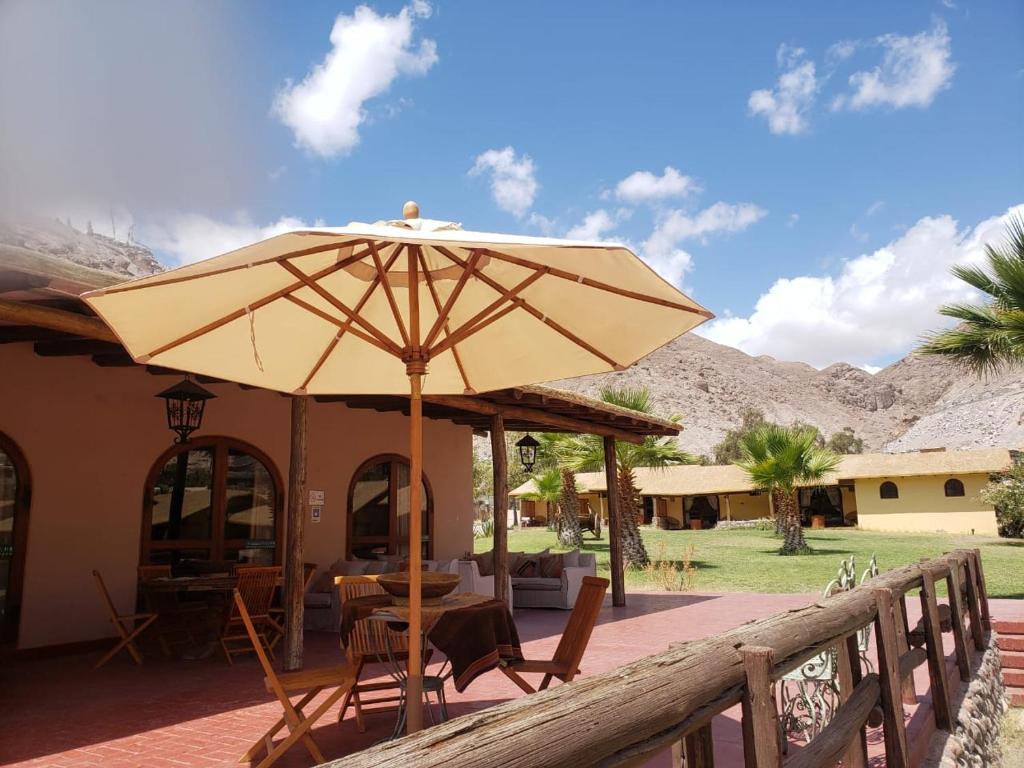 Codpa的住宿－Aruma Codpa，庭院配有遮阳伞和桌椅。