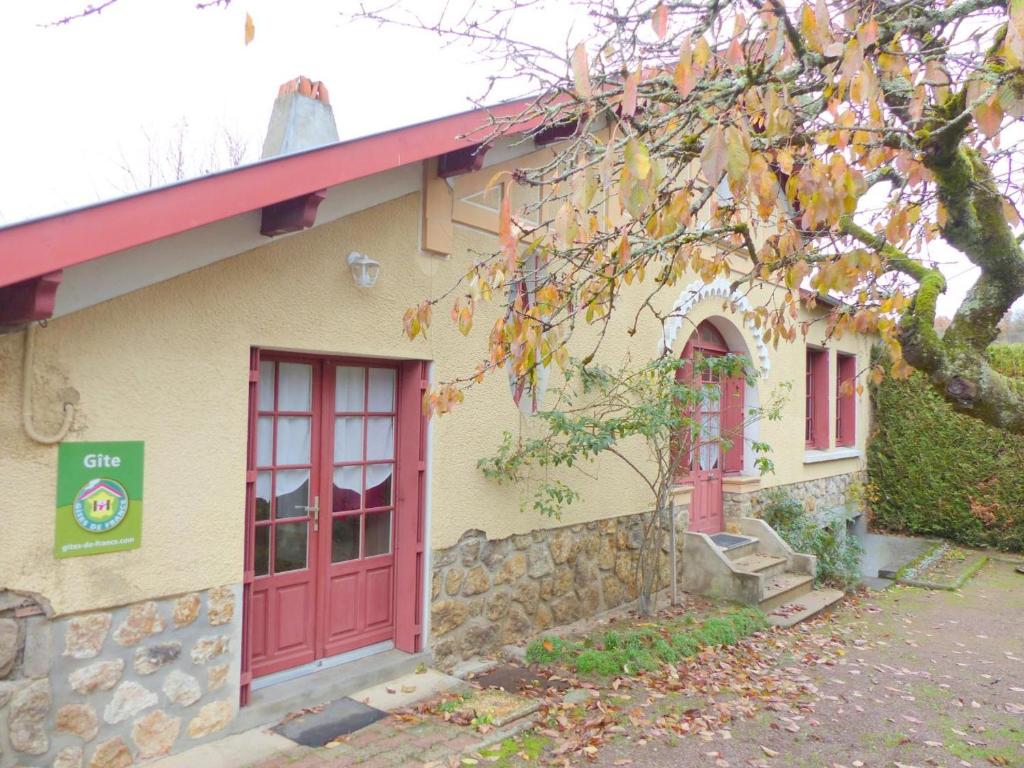 een huis met een rode deur en een boom bij Gîte Hérisson, 3 pièces, 5 personnes - FR-1-489-15 in Hérisson