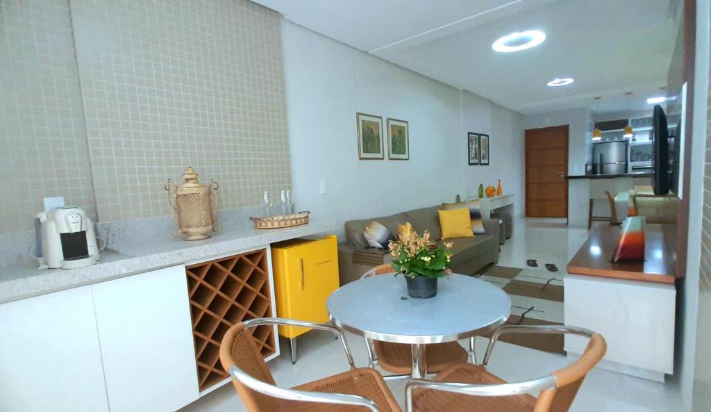 een keuken en een woonkamer met een tafel en stoelen bij Ap Luxo e Requinte em Guarapari in Guarapari