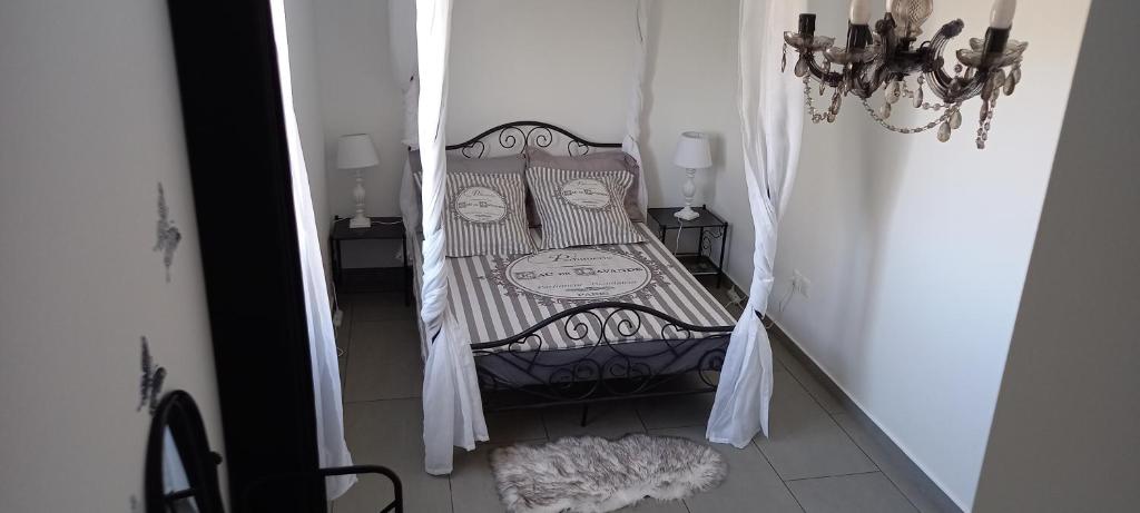 ein kleines Bett im Flur mit Vorhängen und Boden in der Unterkunft Maison Job in Saint-Louis