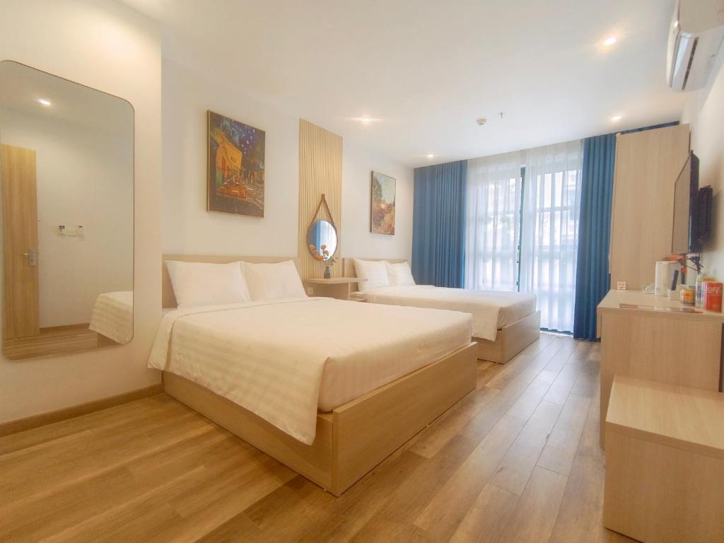 Habitación de hotel con 2 camas y espejo en Elene Phu Quoc en Phu Quoc