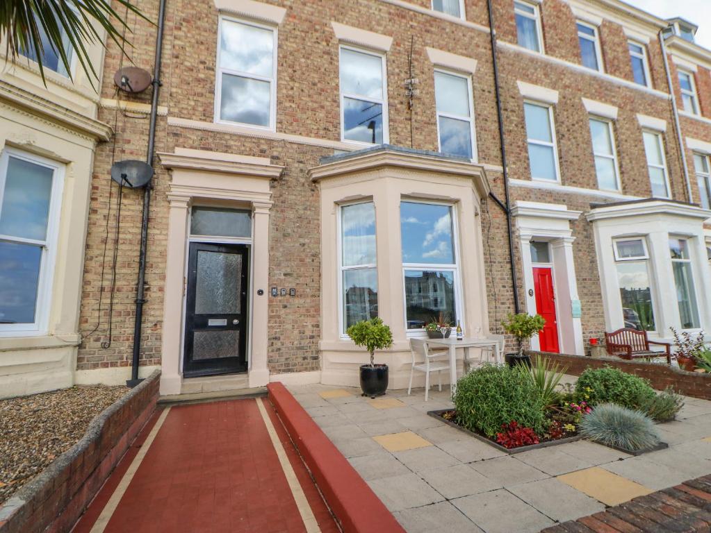 a brick building with a table in front of it at Grand Sea View in North Shields