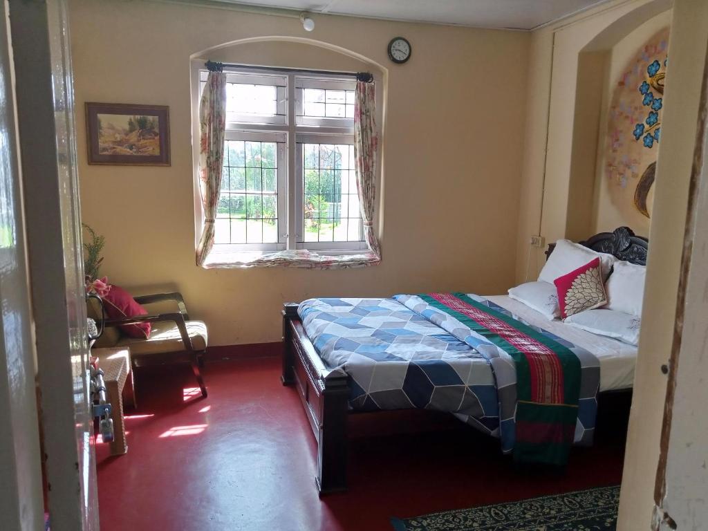 a bedroom with a bed and a window at Zeus Bungalow in Kotagiri