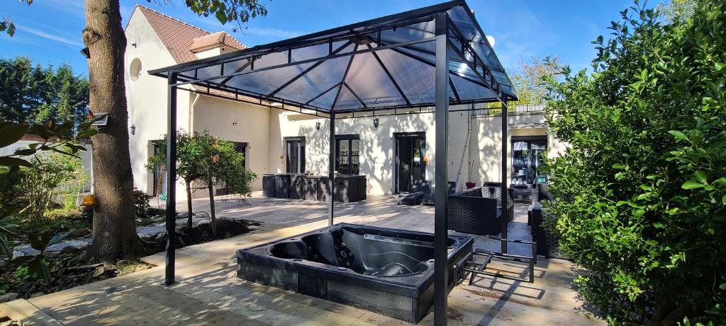 een glazen huis met een bad in het midden van een tuin bij 230m2 sur 3800m2 - jacuzzi 6 places - 10 à 16pers in Pontault-Combault