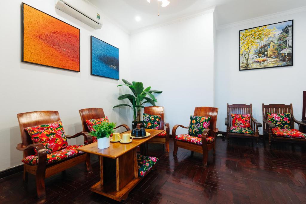 een woonkamer met stoelen en een tafel en stoelen bij Legume House - 30m to centre in Hanoi