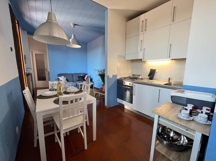 una cocina con armarios blancos y una mesa y sillas blancas. en 2-bedroom flat in the heart of Bergamo city centre, en Bérgamo