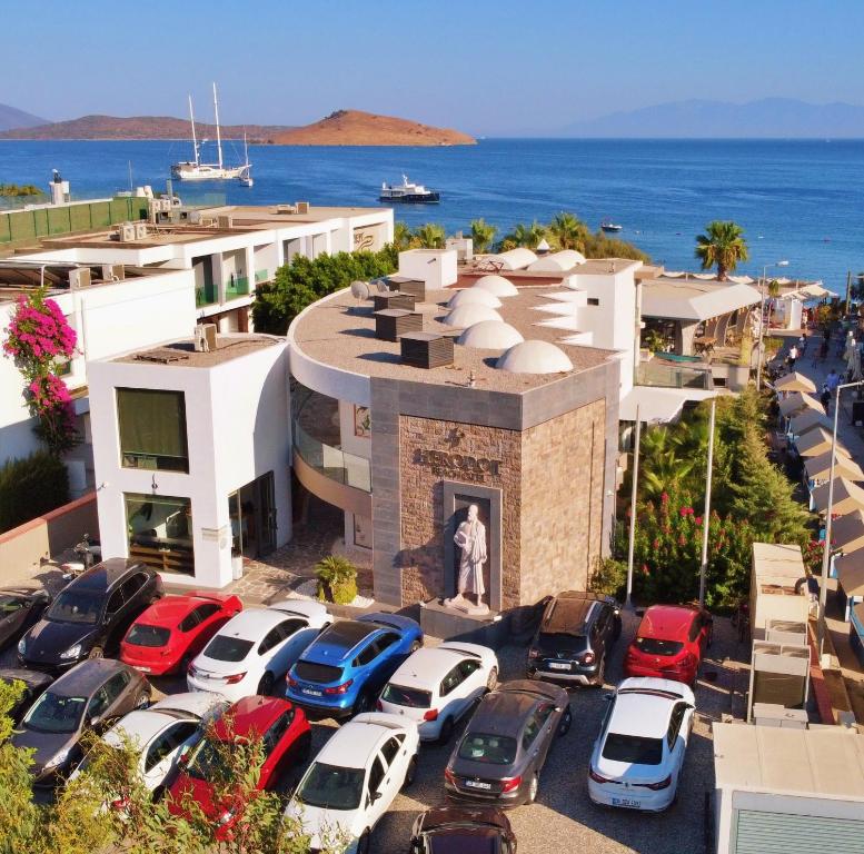 een parkeerplaats met auto's voor een gebouw bij Herodot Beach Otel in Mugla