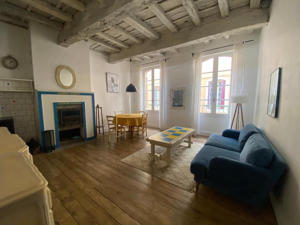 un salon avec un canapé bleu et une table dans l'établissement Maison médiévale Albigeoise en centre ville, à Albi