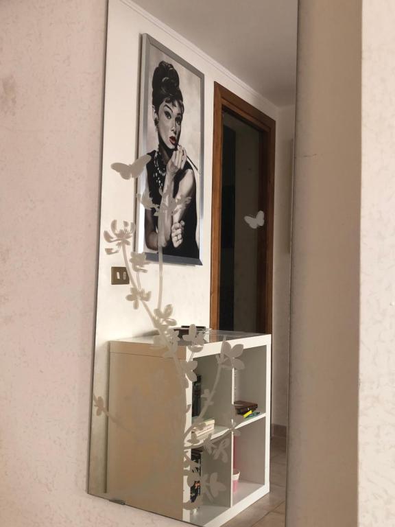 Uno specchio su un muro con la foto di una donna di A.B Battistini Short Let's a Roma