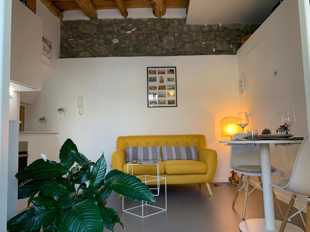 een woonkamer met een gele bank en een tafel bij Villa Paola - Holiday Apartment - Menaggio, Lago di Como in Menaggio